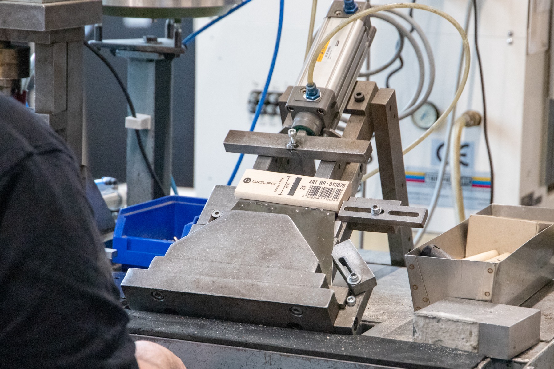 een werknemer welke een lijmkam in elkaar zet met een pers